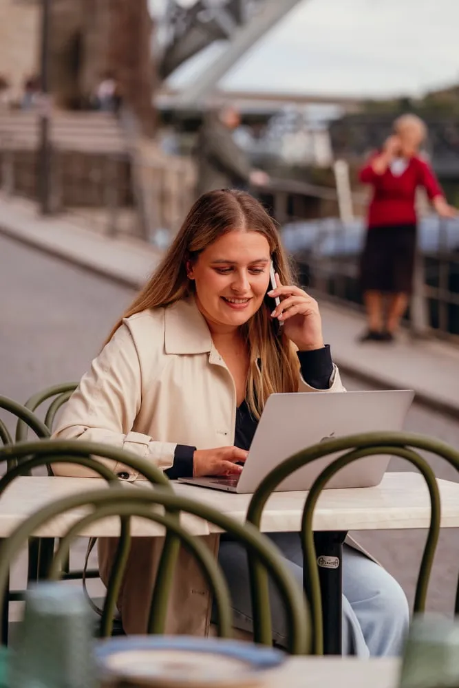 A Sofia ao telefone com o portátil, numa esplanada
