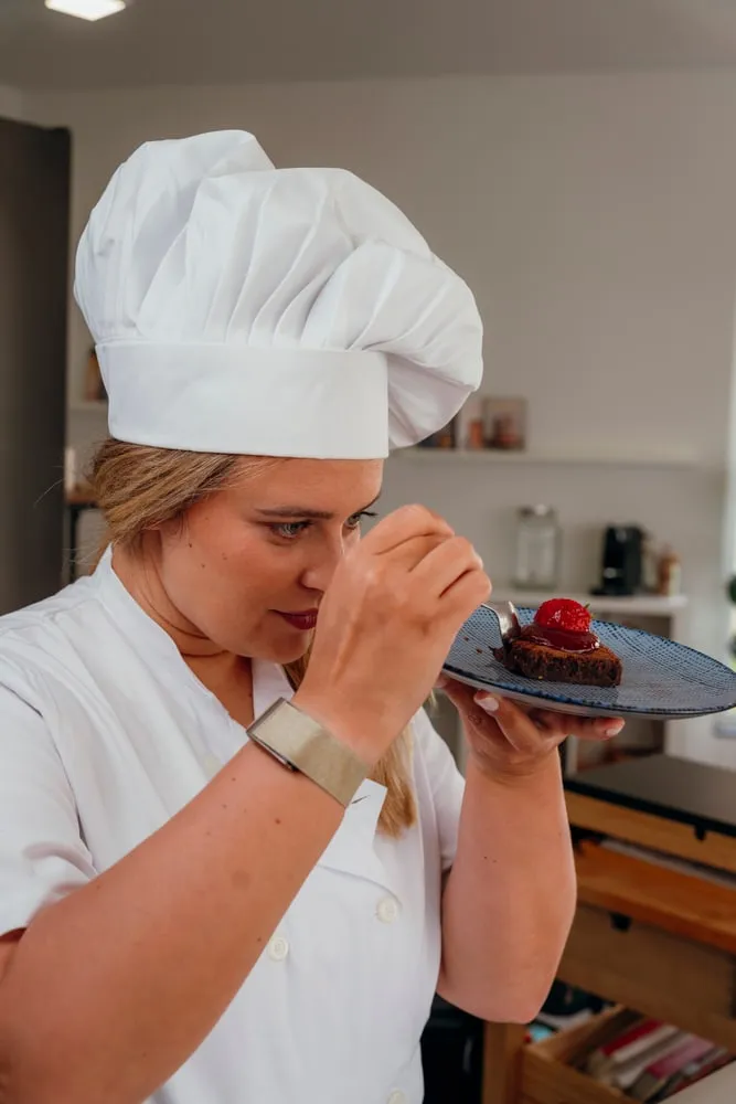 Uma chef a cheirar um prato antes de o servir